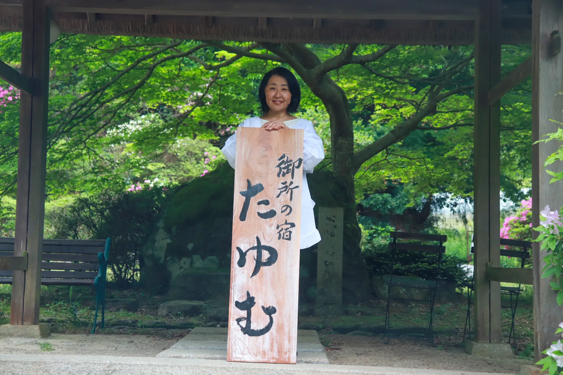 たゆむの看板を手に、笑顔で迎える家主のたにやさん